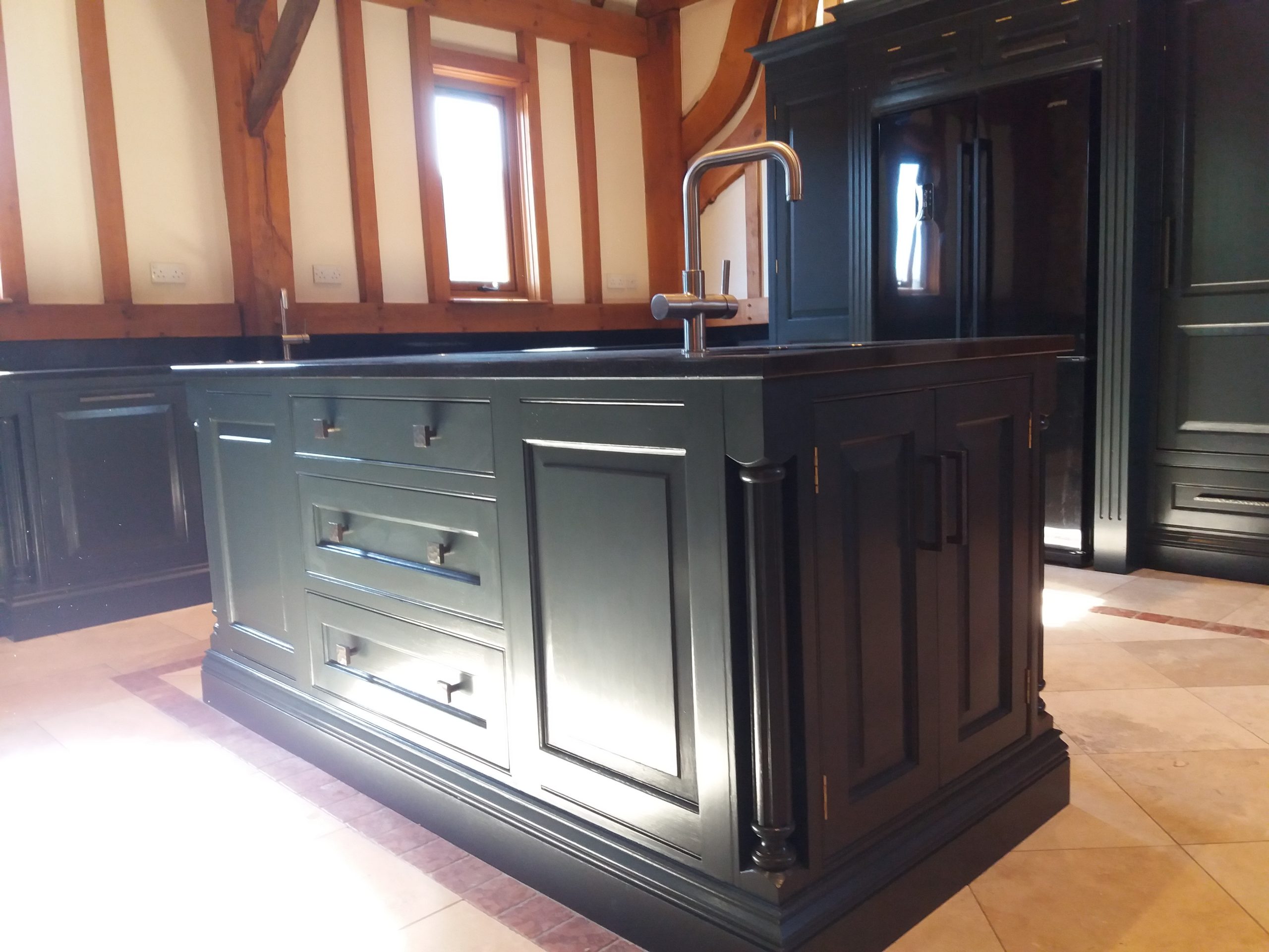 Hand-painted black oak shaker kitchen with a central island and quartz worktops