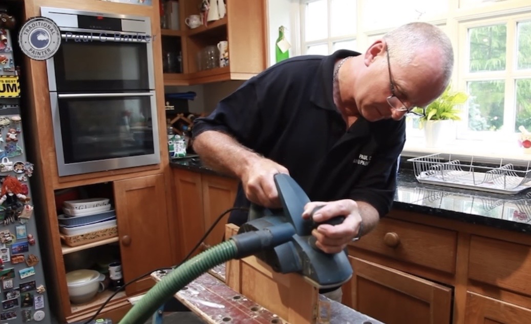 Paul Barber Senior at work hand painting a kitchen cabinet