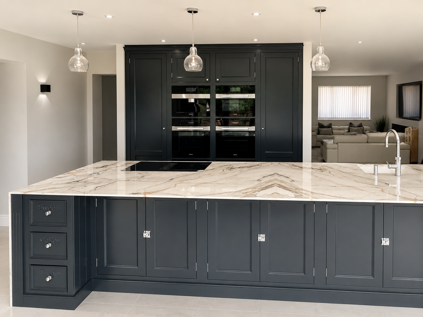 Hand-painted dark grey shaker kitchen with a large marble island, integrated appliances and contemporary pendant lighting.