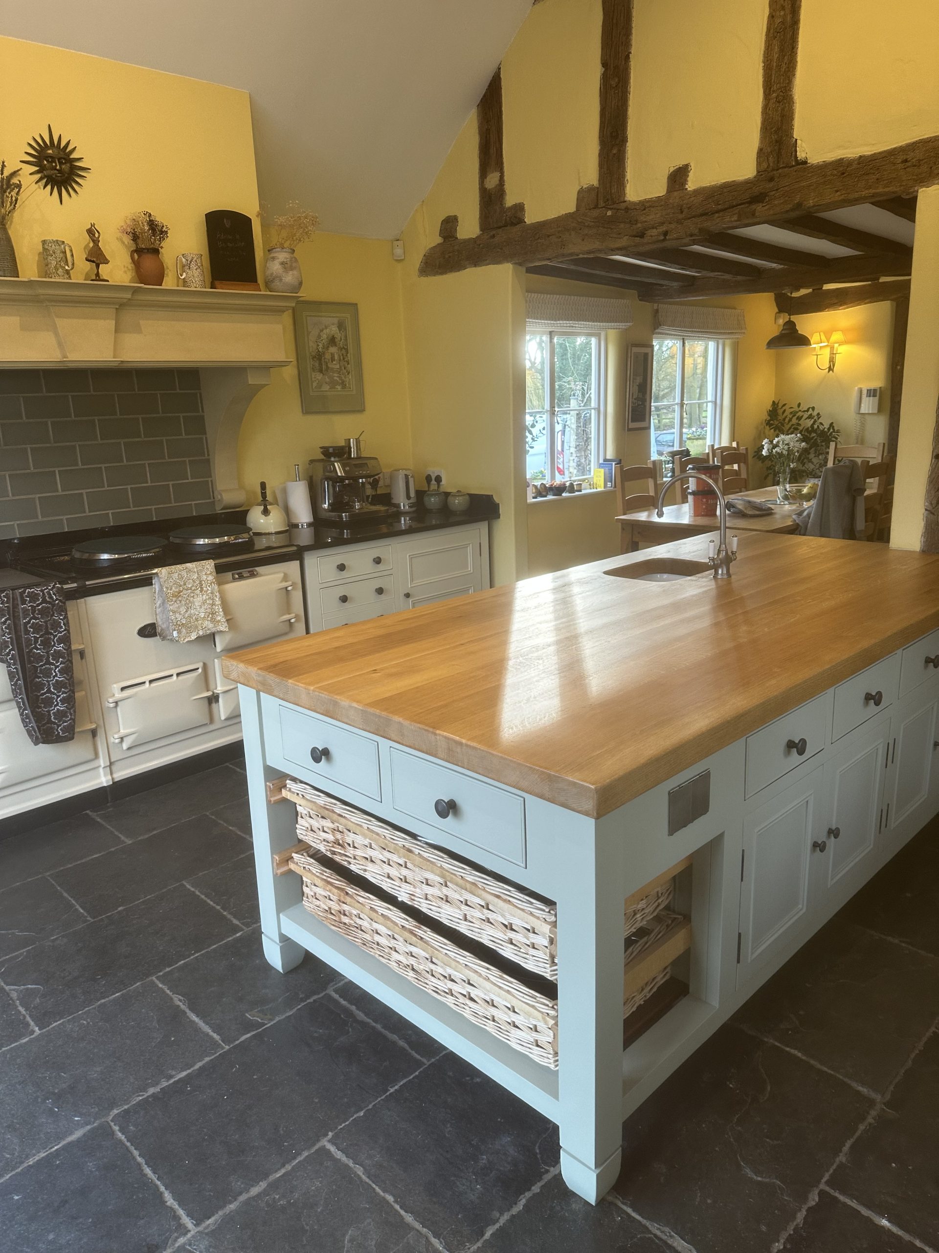 Hand-painted cream shaker kitchen with a solid oak island, tiled floor and bespoke fitted cabinetry.